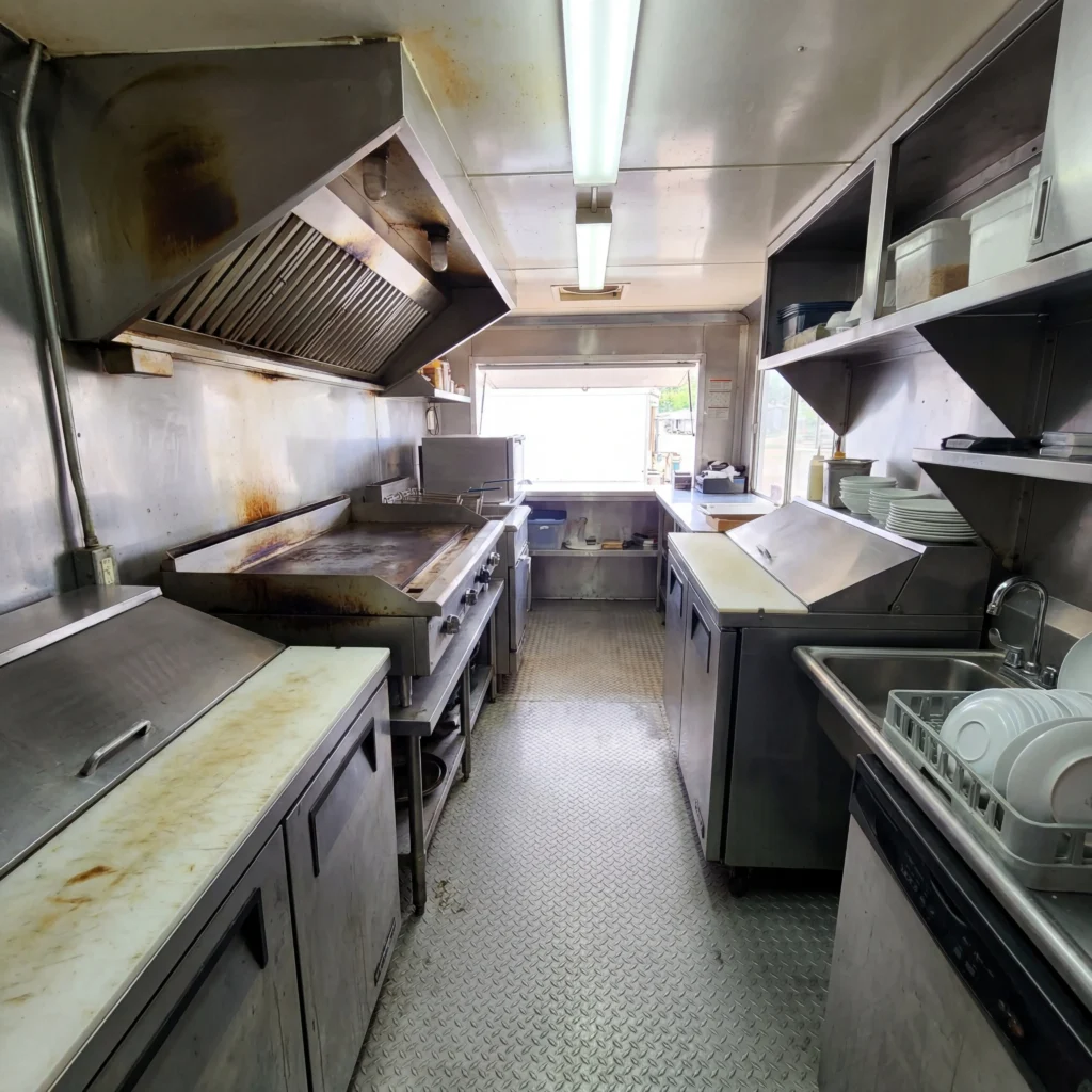Used food truck kitchen interior with stainless steel prep line grill and hood vent