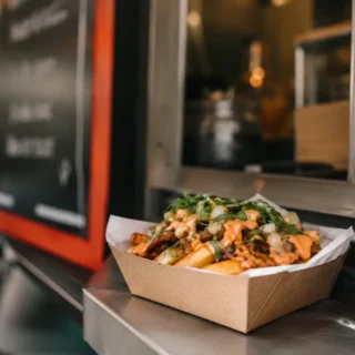 Menu Ideas, a fresh street-food order at a food truck window with a chalkboard menu blurred behind